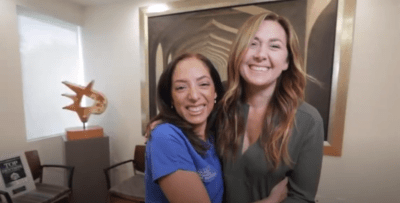 Photo of two women hugging and smiling at the camera