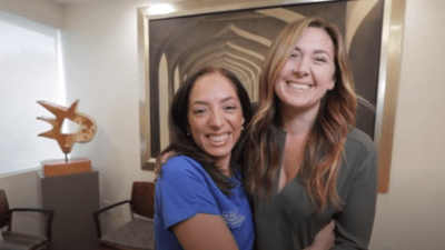 Photo of two women hugging and smiling at the camera