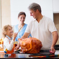 Turkey For Thanksgiving. Family Cooking Festive Dinner. Mother, Father And Child Roast Meat In Decor